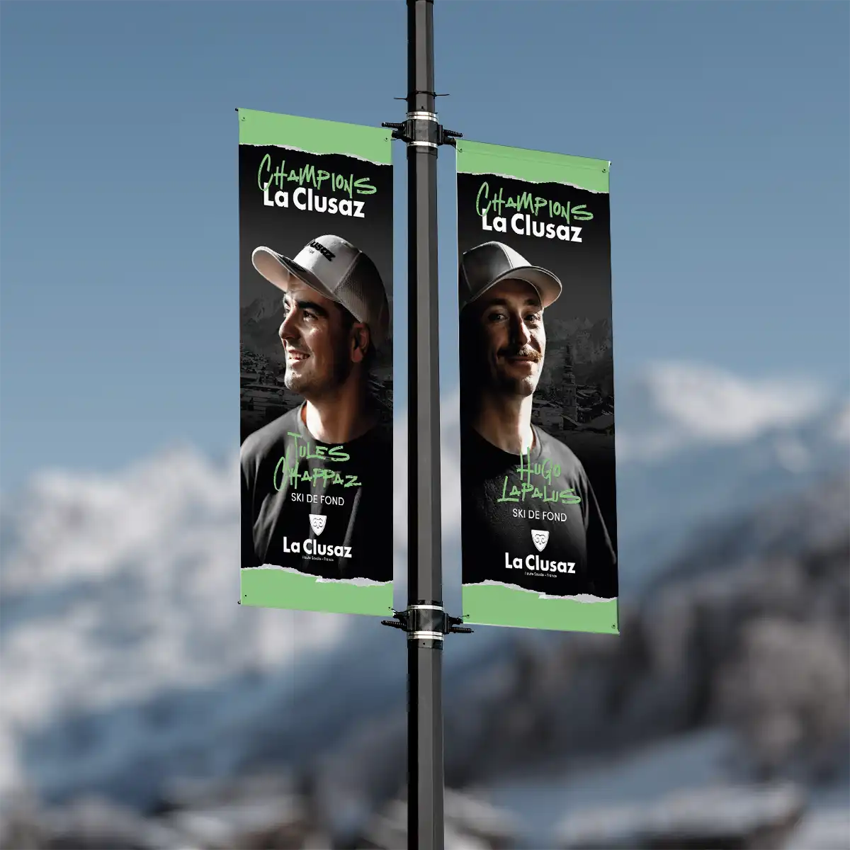 Kakémonos « Champions La Clusaz » sur un mât, avec portraits d’athlètes (Jules Chappaz et Hugo Lapalus).